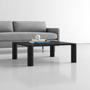 Axton square black wood coffee table with chunky rounded corner legs styled in a living room