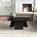 Landyn round black wood coffee table with intersecting panel legs styled in a living room