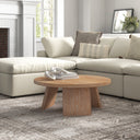 Landyn round natural wood coffee table with intersecting panel legs styled in a living room