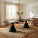 Skyler Solid Wood 8 Seater Dining Table in black with an oval tabletop and textured pedestal legs in a modern dining room.