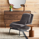 Jaime Tall End Table - round solid wood side table styled beside a green lounge chair in a modern living room.