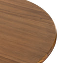 Detailed close-up of the natural wood Kiaan dining table highlighting the rounded tabletop edge, natural grain, and pedestal support.