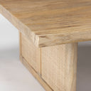 Close up angle view of Lachlan coffee table thick wood tabletop corner and woven rattan leg