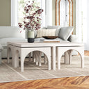 Remi whitewashed wood nesting coffee table set with arched cutout details in a bright living room