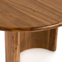 Front detail of the natural wood Kiaan dining table showing the cylindrical pedestal leg and slim rounded tabletop edge.