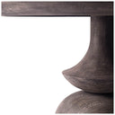Side detail of the Musa Round Dining Table showing the slim rounded tabletop profile and sculpted pedestal beneath.