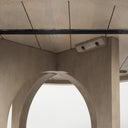 Close-up underside view of the Loyal dining table showing the natural wood tabletop, pedestal structure, and hardware details. 