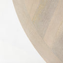 Detailed close-up of the Loyal dining table showcasing the natural wood grain and curved edge of its circular pedestal structure.