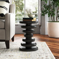 Clyde round black solid wood end table with stacked geometric disc pedestal base styled in a room