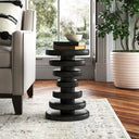 Clyde round black solid wood end table with stacked geometric disc pedestal base styled in a room