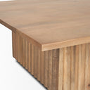 Close up angle view of Davian coffee table showing square corner edge and fluted wood base detail