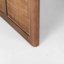 Close up detail of dark wood leg frame with woven cane panel insert on Lachlan coffee table
