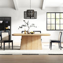 Langston Dining Table in natural wood finish styled in a bright dining room with black dining chairs, pendant lighting, and decorative tableware.
