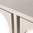 Close up angle view of Remi whitewashed wood nesting coffee table corner showing grain texture and nested leg gap