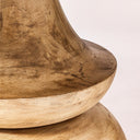 Close-up of the Musa Dining Table pedestal featuring its smoothly curved profile and distinctive natural wood grain.