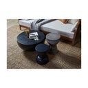 Jerry grey textured hourglass table styled in a living room with black round wood coffee tables