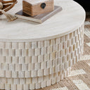 Angled top view of Khari white drum coffee table styled with decorative wooden box and books