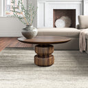 Rey round dark walnut solid wood coffee table with double stacked pedestal base in a living room