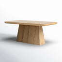 Angled view of the natural wood Langston Dining Table showcasing the softly rounded tabletop edges and sculptural tapered pedestal support.
