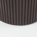 Detailed side view of the dark Mylo Dining Table, highlighting the slim rounded tabletop and sculptural central pedestal.