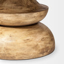 Detailed view of the rounded lower base of the Musa Round Dining Table with visible natural wood texture and tonal variations.