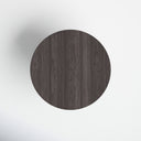 Top-down view of the Musa Round Dining Table displaying its circular dark wood surface and subtle grain pattern.