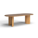 Angled view of the natural wood Kiaan Oval 6 Seater Dining Table showcasing its rounded oval tabletop and matching wooden pedestal legs.