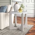 Cullen round white stone top end table with light grey arched wood cross legs styled in a room