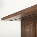 Underneath view of Lachlan dark wood coffee table showing structural metal brackets and cane panel legs