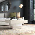 Ben square cream coffee table with textured fluted pedestal base in a dark modern living room