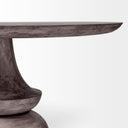 Close-up view of the dark wood pedestal base on the Musa Round Dining Table, emphasizing its layered curved forms and craftsmanship.