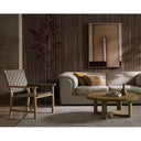 Blaise round wooden coffee table paired with a lounge chair in a cozy living area