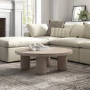 Vicente round solid wood coffee table with thick cylindrical legs styled in a cozy living room