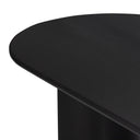 Side detail of the black Kiaan dining table showing its slim rounded tabletop edge and cylindrical pedestal support.