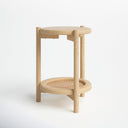 Jerry round natural wood 2-tier end table side studio view showcasing woven rattan shelf