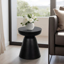 Matte black concrete drum end table with flowers styled in a bright living room