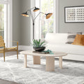Jefferson oval light wood coffee table with curved panel slab legs in a bright living room