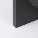 Close-up underside view of the black Loyal dining table showing the pedestal construction, circular cutout, and connecting hardware.