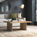 Lachlan square solid wood coffee table with woven rattan panel legs in a dark modern living room