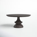Musa Round Dining Table shown in a deep dark wood finish against a white background, highlighting its sculptural pedestal silhouette.