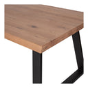 Close-up of the Emir Dining Table corner showing the thick solid wood tabletop, natural grain and black metal leg connection.