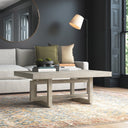 Mauricio rectangular light wood coffee table with open trestle geometric base in a modern living room