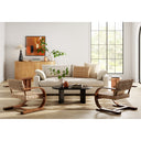 Lee oval black wood coffee table styled in a bright modern living room with woven accent chairs