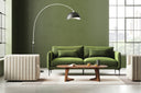 Donald oval walnut wood coffee table styled in a modern green living room with an arc floor lamp
