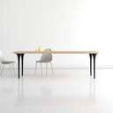 Landyn Solid 6 Seater Dining Table displayed against a clean background, showcasing its natural wood top, rounded edges and four slim black legs.