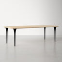 Landyn Solid 6 Seater Dining Table with a natural wood tabletop and slender black tapered legs in a bright modern dining room.