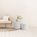 Cohen End Table set featuring two white cylindrical tables beside a neutral upholstered chair.