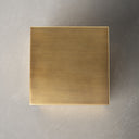 Top down view of Dante table showing square brushed brass finish metal surface