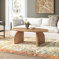 Quinton oval natural wood coffee table with curved panel slab legs styled in a modern living room