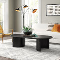 Louie oval black wood coffee table with curved panel slab legs styled in a modern living room